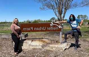 Student Standing Next to a Sign